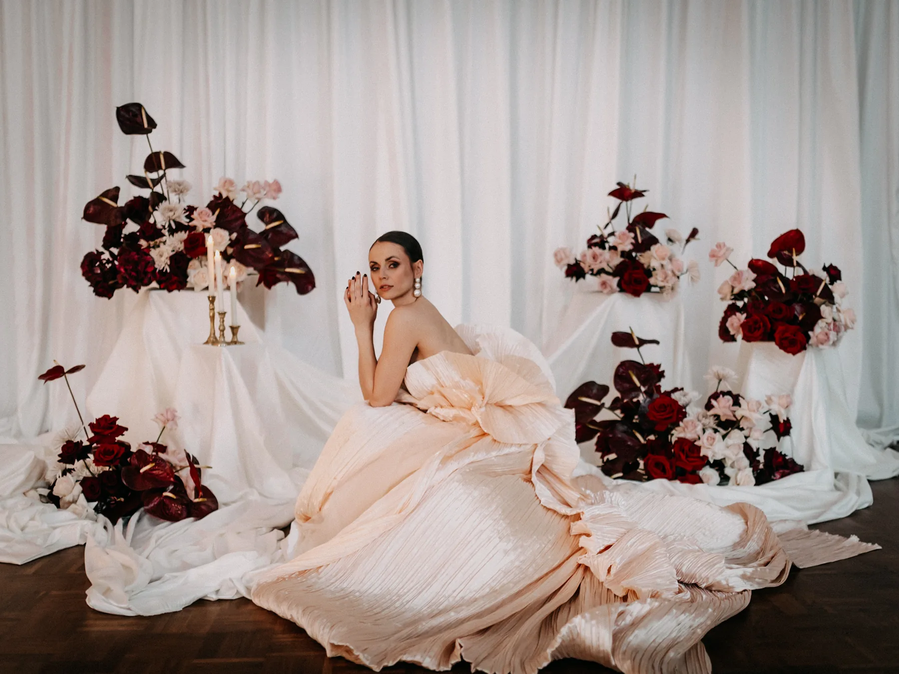 Fine-Art – Model in Pfirsich-Robe sitzend vor floraler Kulisse